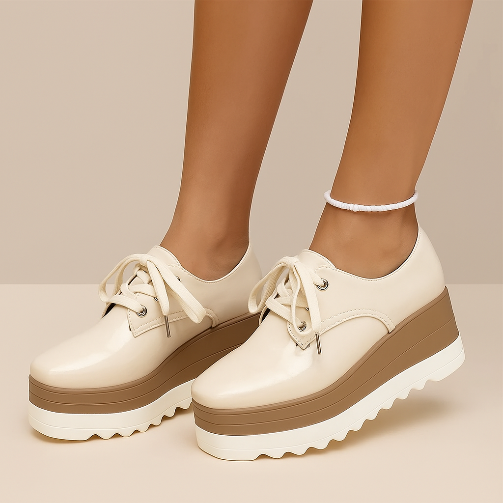 White platform shoes with brown soles worn by a person on a beige background