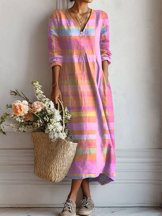 Person wearing a colorful striped dress holding a woven bag with flowers indoors.