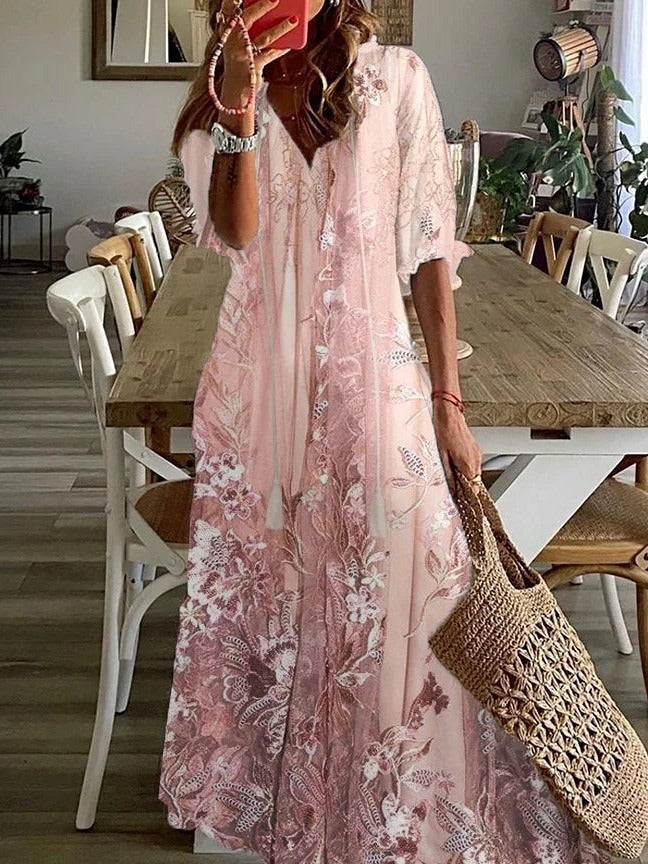 Woman in a pink floral dress holding a woven bag in a dining room.