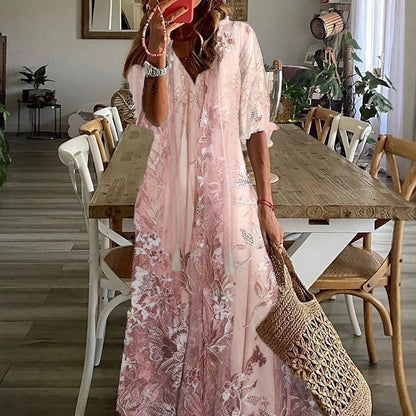 Woman in a pink floral dress standing in a dining room with a woven bag.