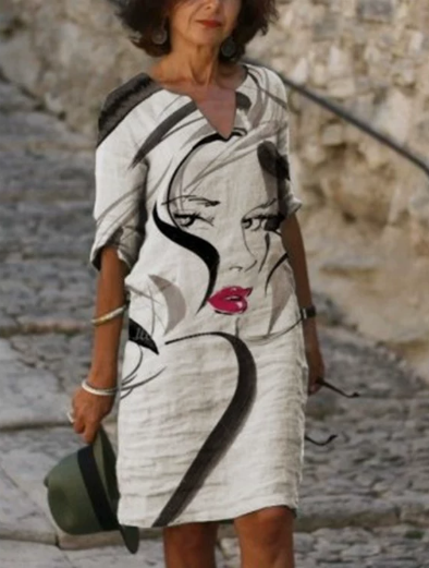 Woman wearing a dress with artistic design outdoors.