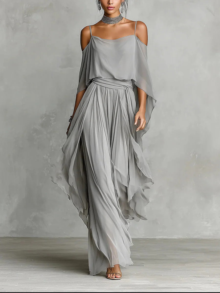 Woman wearing a flowing gray dress against a plain background