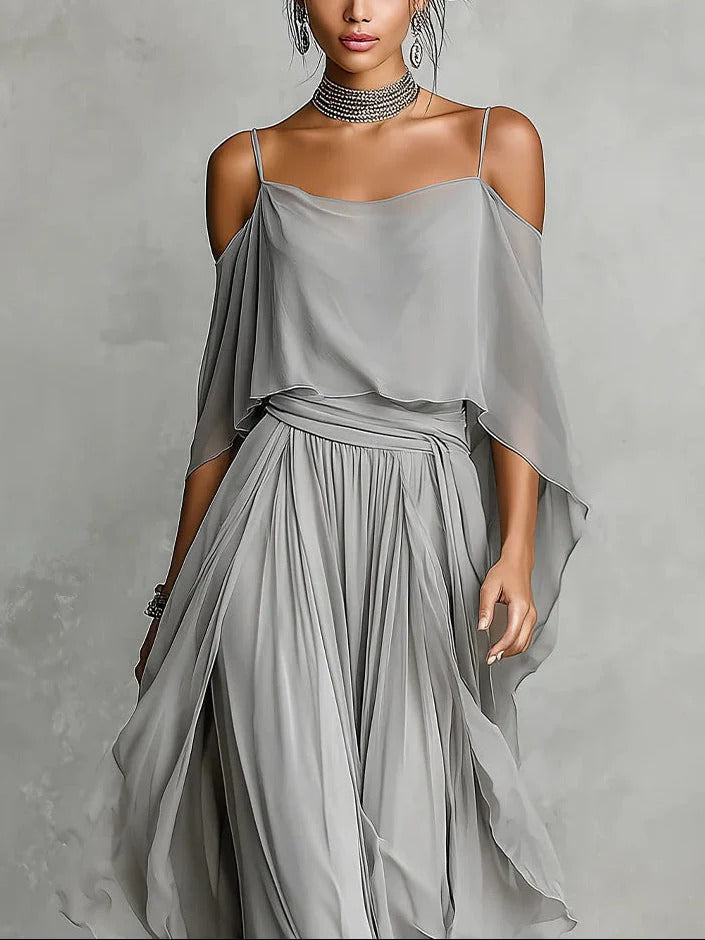 Woman wearing a gray off-shoulder dress against a gray background