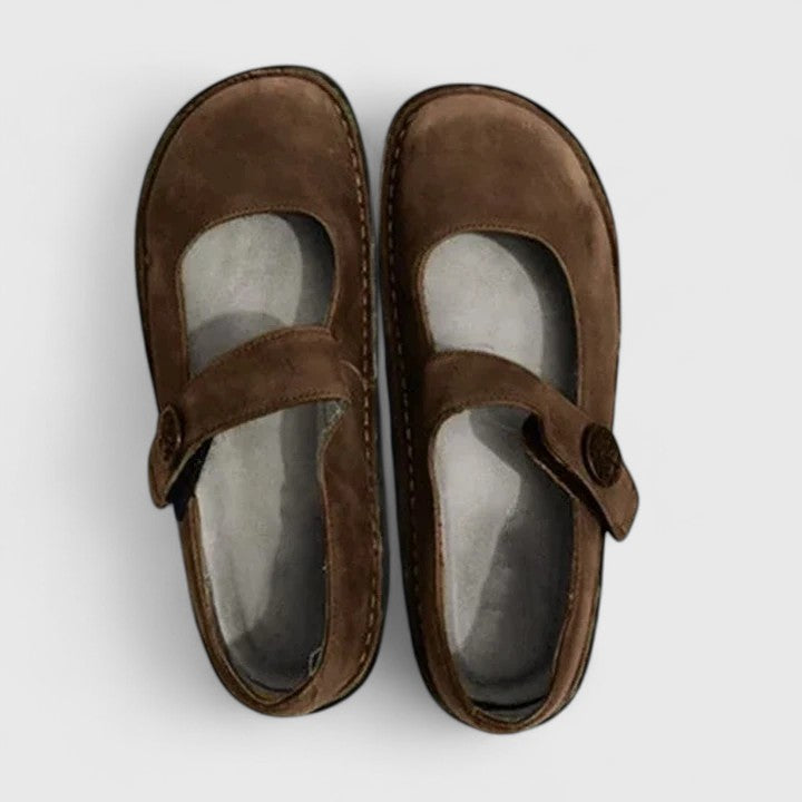 Pair of brown children's shoes with a strap on a white background