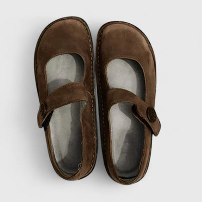 Pair of brown children's shoes with a strap on a white background