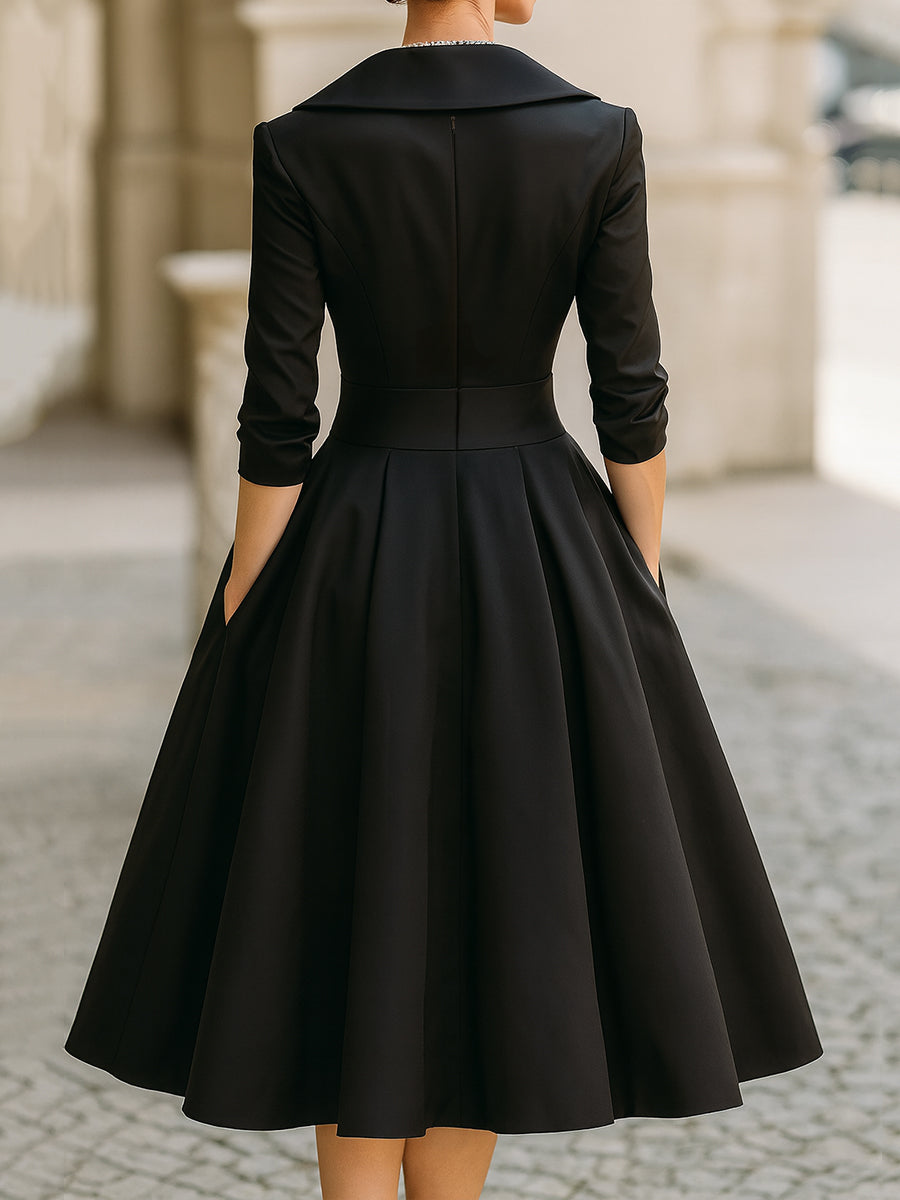 Black dress with long sleeves and a full skirt on a blurred street background