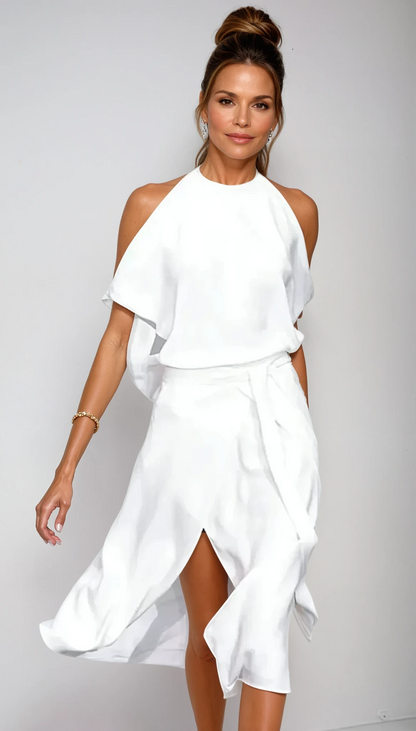 Woman wearing a white dress against a plain background