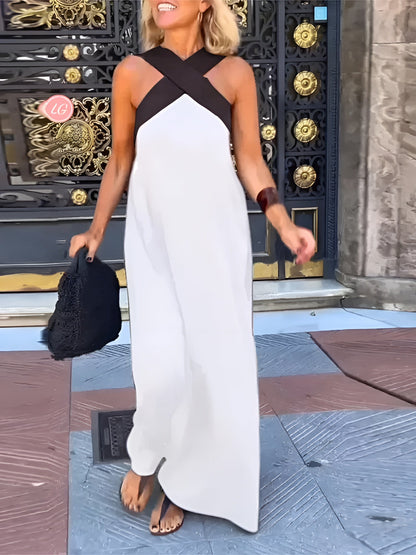 Woman in a white and black dress standing in front of ornate doors.