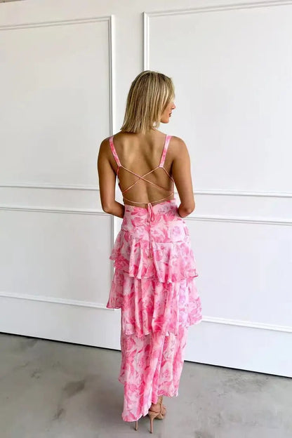 Woman wearing a pink floral dress with a white paneled wall background