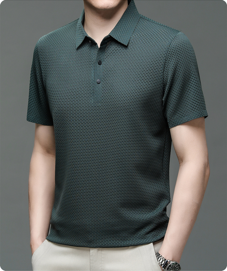 Man wearing a dark green patterned polo shirt on a gray background