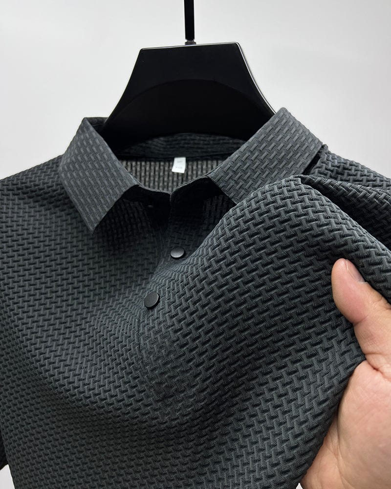 Gray textured polo shirt on a hanger with a hand holding it