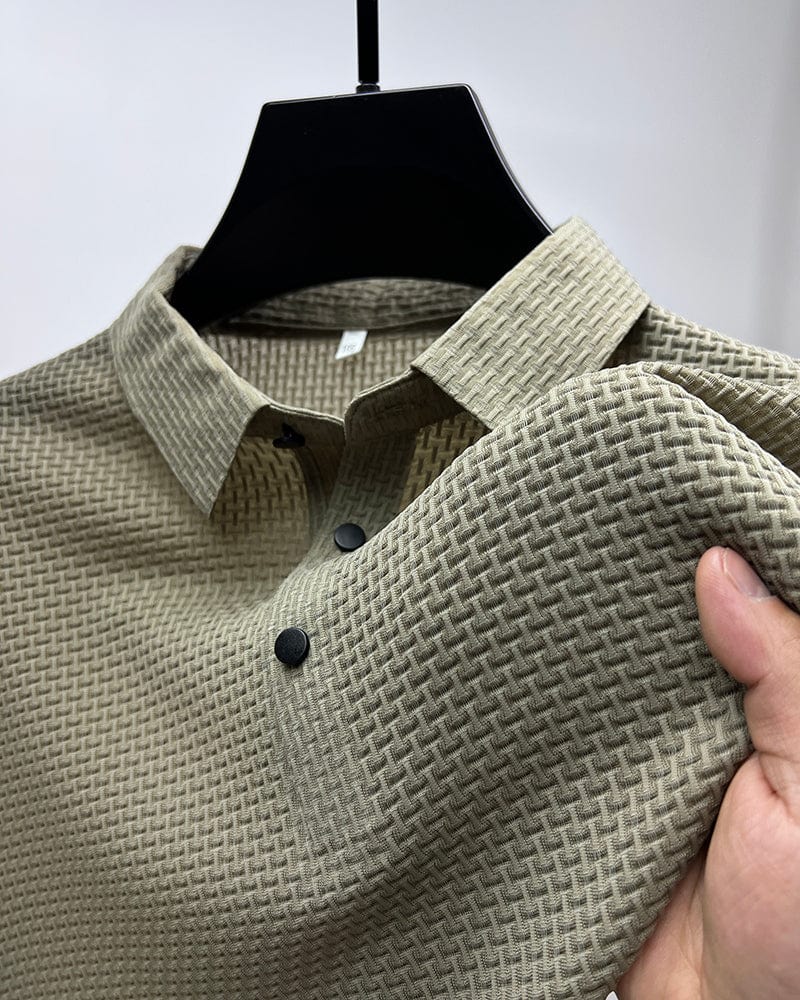 Beige textured shirt on a hanger with a hand holding it