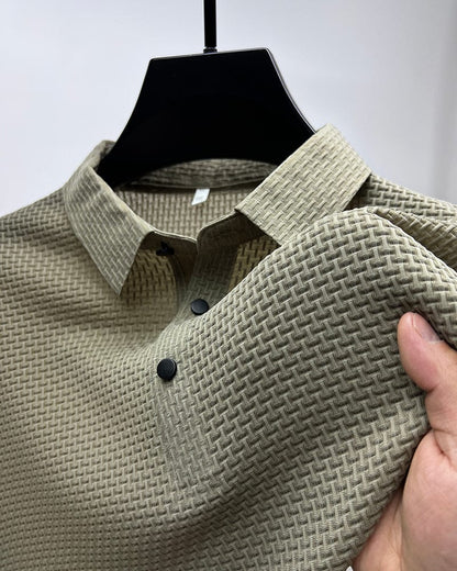 Beige textured shirt on a hanger with a hand holding it