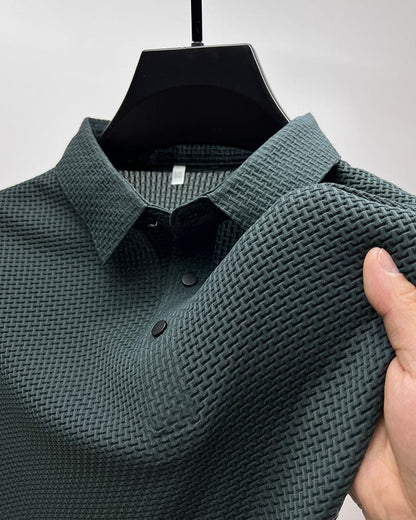 Green textured shirt on a hanger with a hand holding it