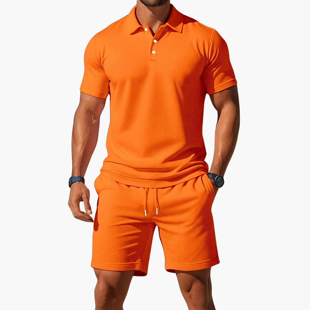 Man wearing an orange polo shirt and shorts set on a white background