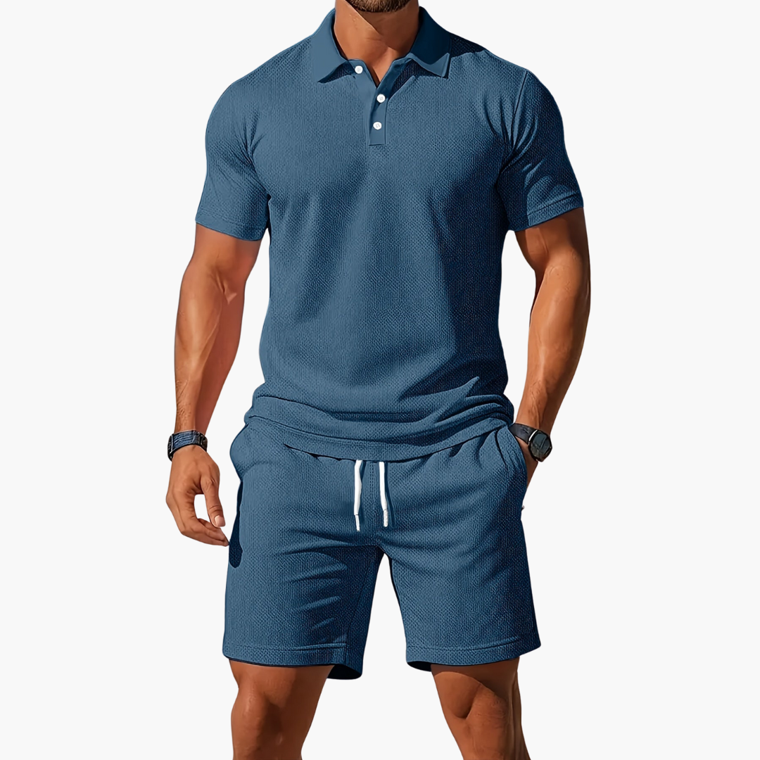 Man wearing a blue polo shirt and shorts set on a white background
