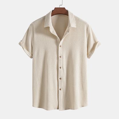 Beige checkered shirt on a hanger against a white background