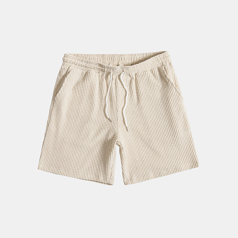 Beige shorts with a drawstring on a light gray background