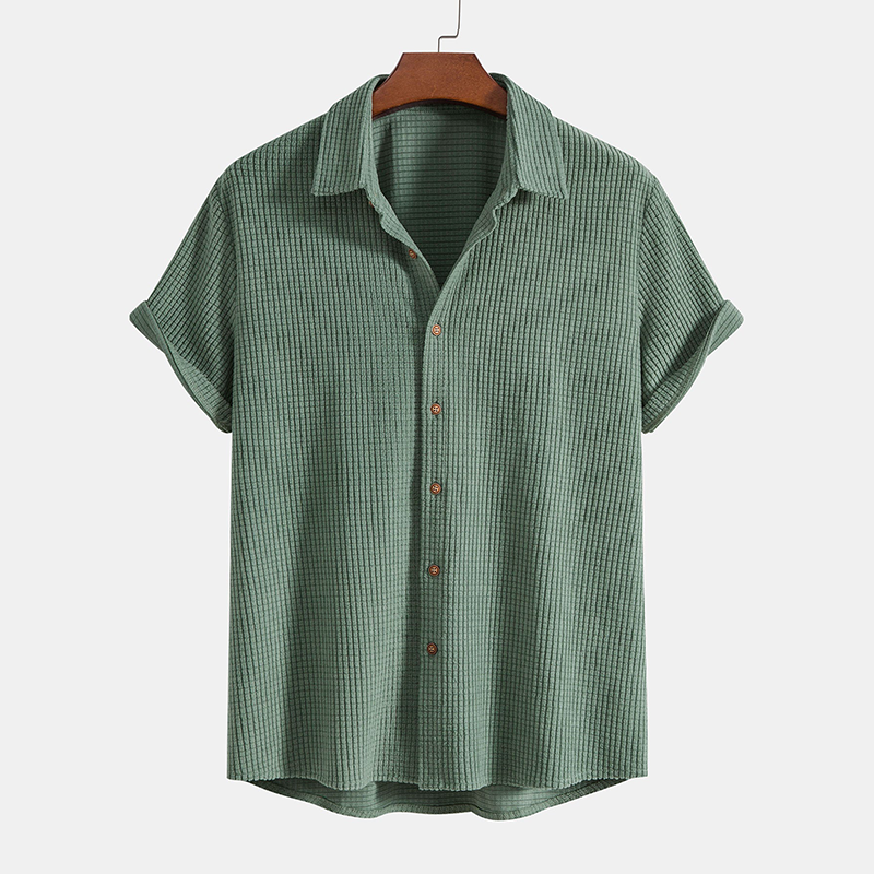 Green checkered shirt on a hanger against a white background