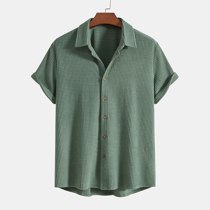 Green checkered shirt on a hanger against a white background