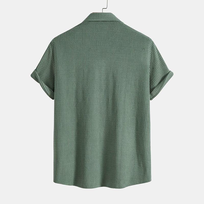 Green checkered shirt on a hanger against a white background