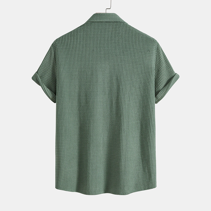 Green checkered shirt on a hanger against a white background