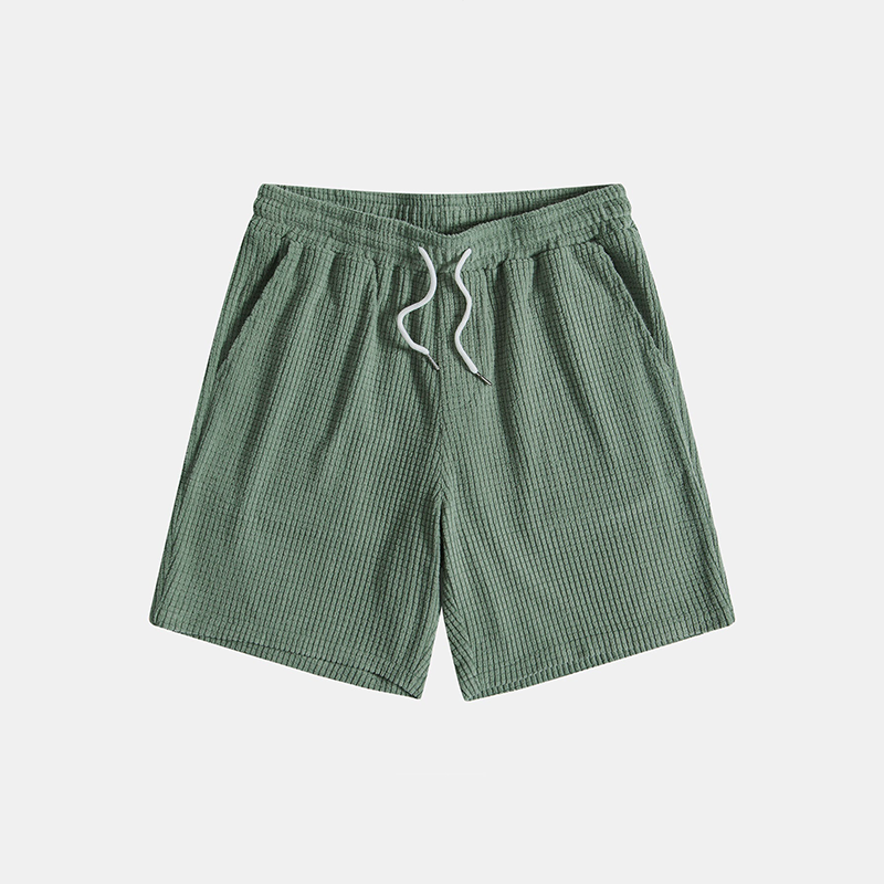 Green checkered shorts with a drawstring on a light gray background