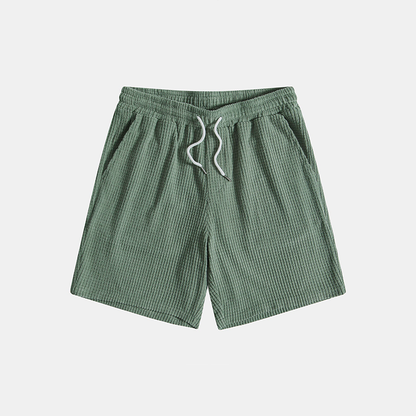 Green checkered shorts with a drawstring on a light gray background