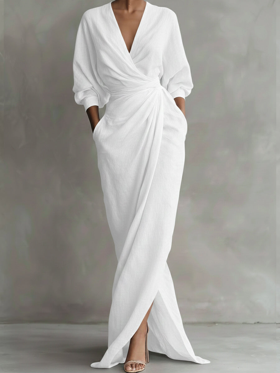 White dress with a deep V-neck and long sleeves on a gray background