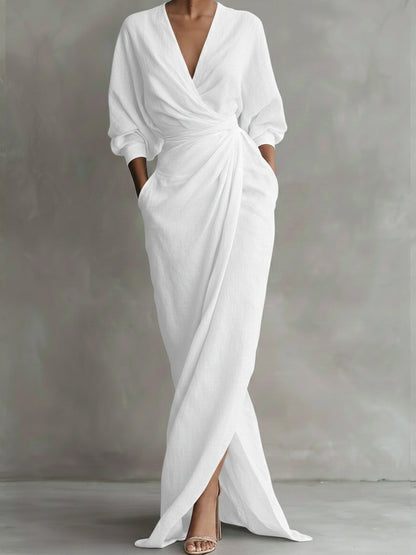 White dress with a deep V-neck and long sleeves on a gray background