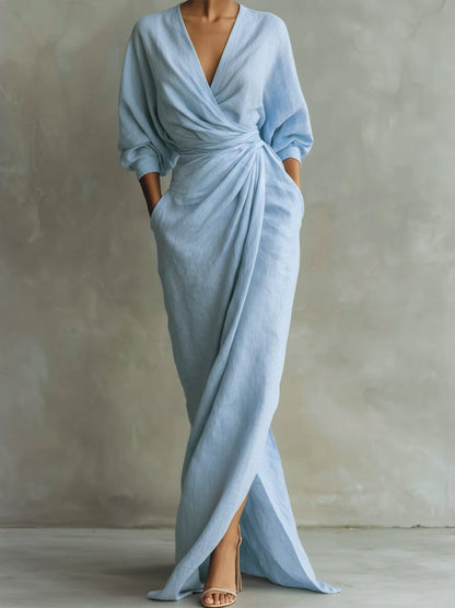 Light blue dress with a V-neck and long sleeves on a neutral background
