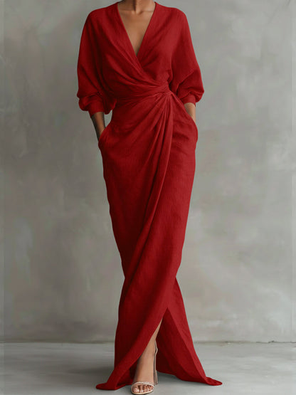 Red evening gown with a deep neckline and long sleeves on a plain background