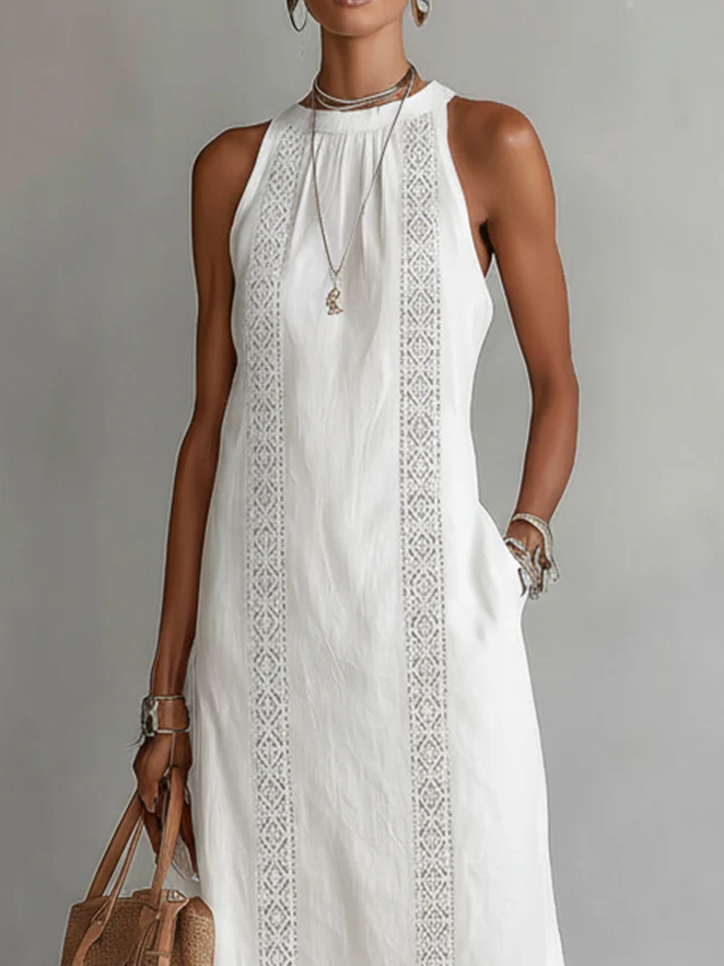 Woman wearing a white sleeveless dress with lace details against a gray background