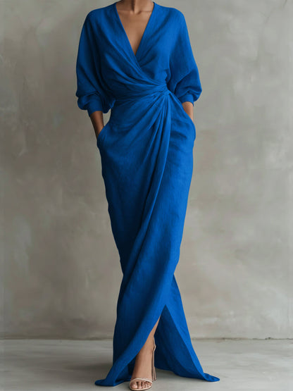Blue evening gown with long sleeves on a plain background