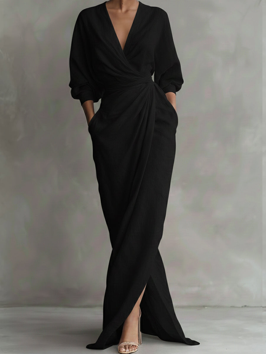Black evening gown with a deep V-neck and long sleeves on a plain background