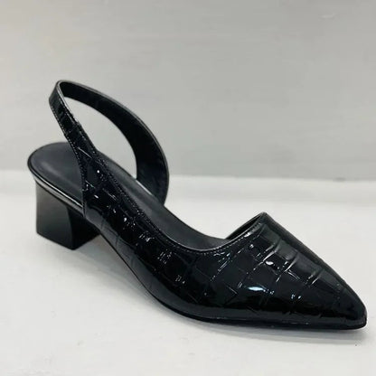 Black patent leather slingback shoe on a white background