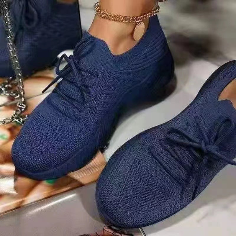 Blue sneakers worn by a person on a reflective surface