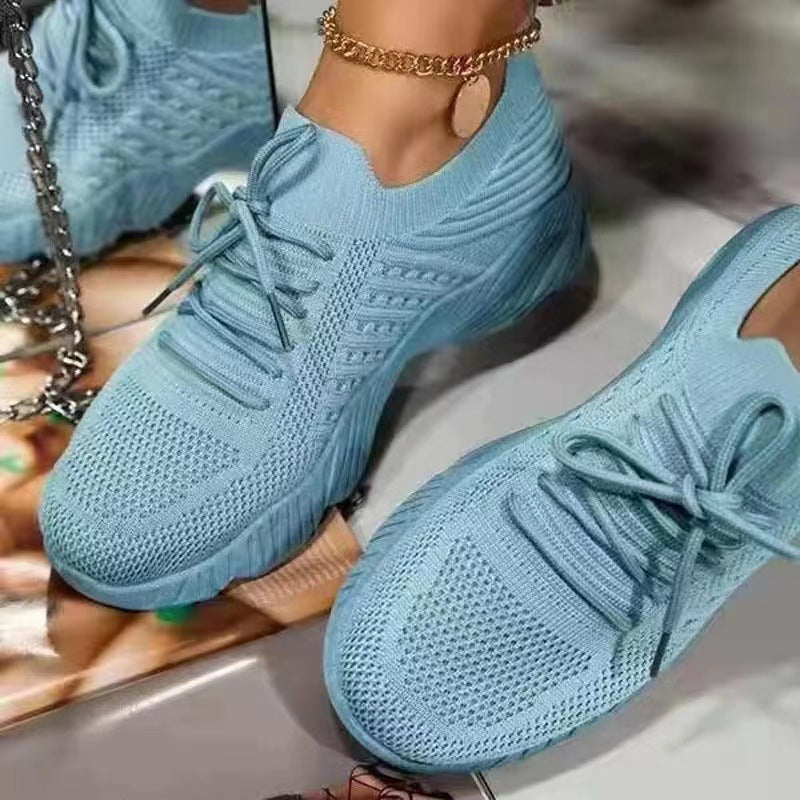 Blue sneakers worn by a person with a blurred background