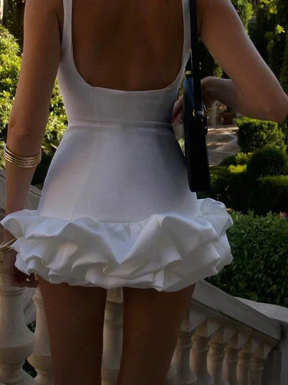Person wearing a white dress with ruffled skirt in an outdoor setting