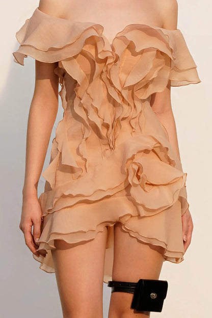 Beige ruffled dress worn by a model on a plain background