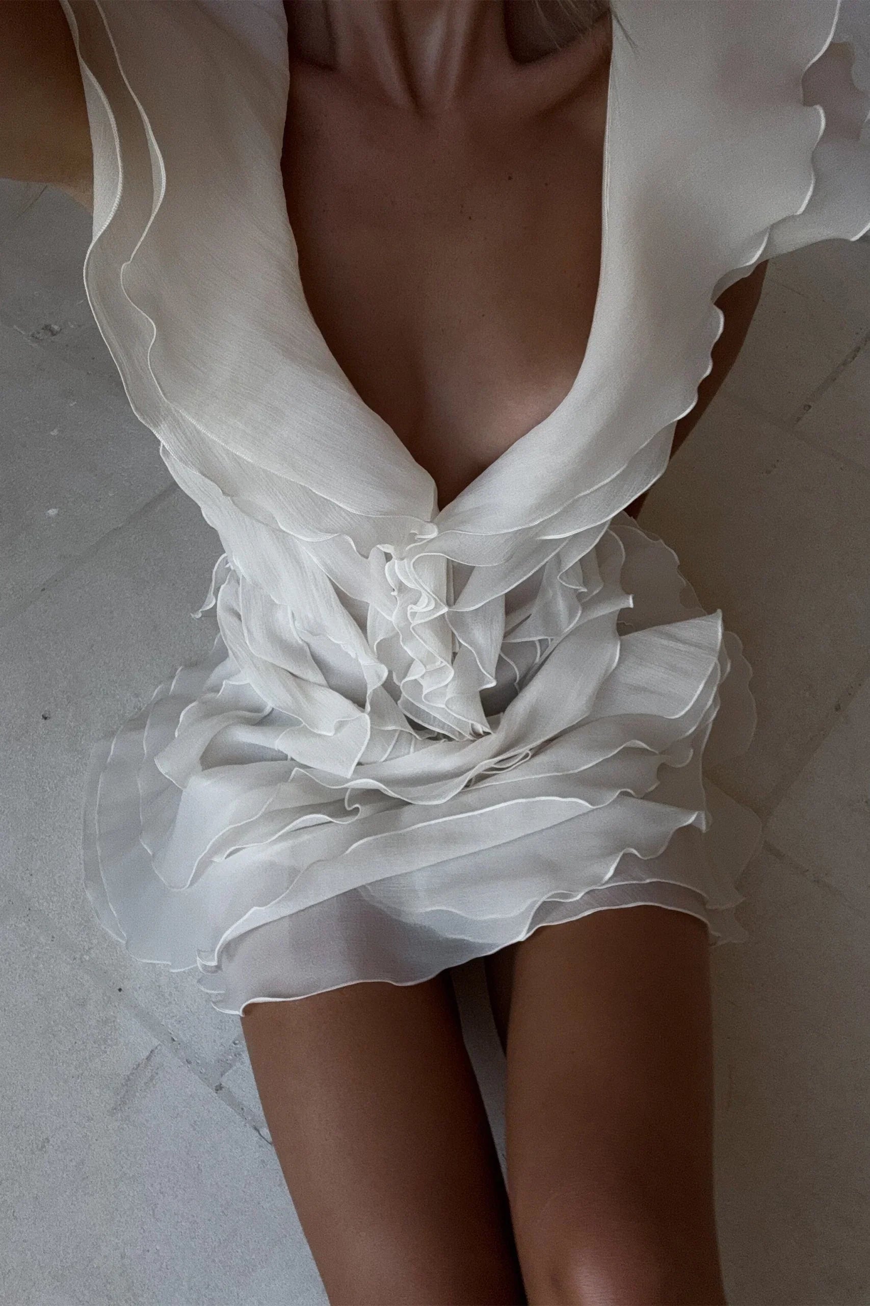White ruffled dress on a neutral background