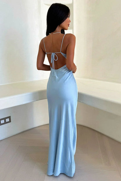 Woman wearing a light blue evening gown in a minimal indoor setting