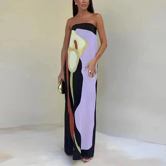 Woman wearing a strapless dress with abstract design on a plain background
