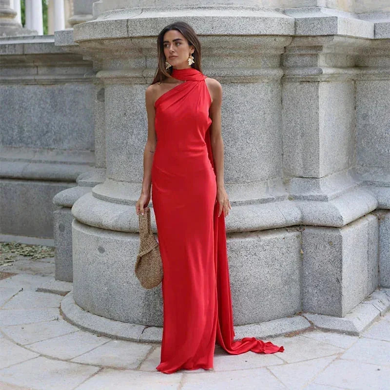 Woman in a red dress standing in front of stone architectural elements