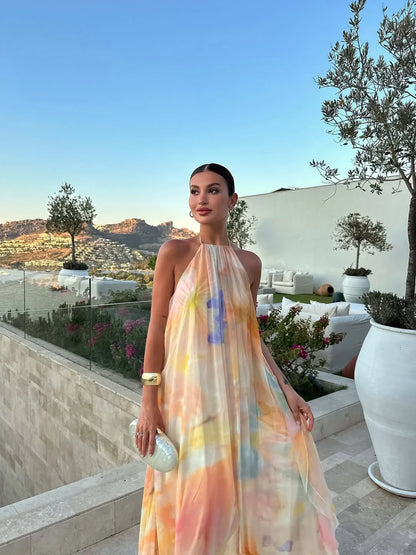 Woman in a colorful dress standing on a rooftop with scenic views and plants.