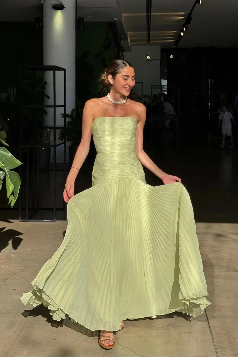Woman wearing a light green strapless dress in an indoor setting