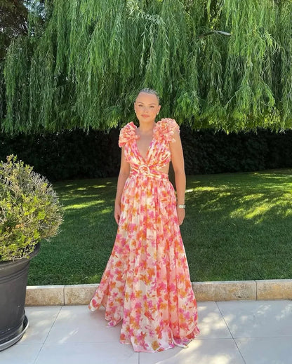 Woman in a floral dress standing outdoors with greenery in the background