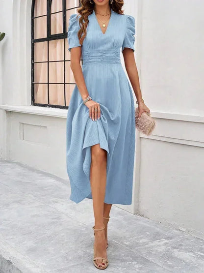 Woman wearing a light blue dress with a white background