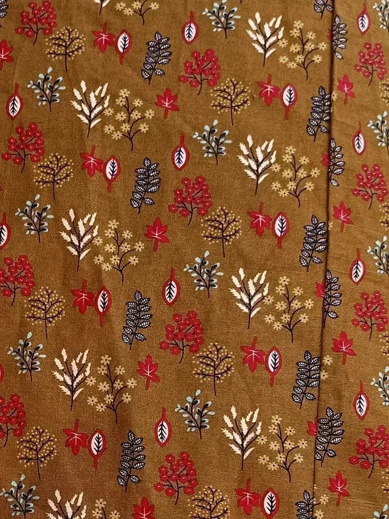 Patterned fabric with autumnal leaves and berries on a brown background