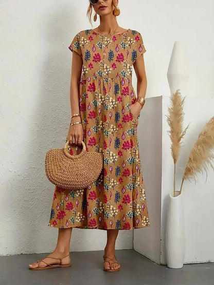 Woman wearing a floral dress holding a woven bag against a white wall.
